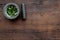 Harvest medicinal herbs. Greens in mortar bowl on dark wooden background top view copy space