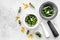 Harvest medicinal herbs. Greens in mortar bowl and herbs in small bottles on grey background top view copy space