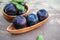 Harvest plums in a wooden dish on a wooden rustic background. Copy space