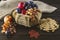 Harvest of ripe apples, plums, grapes in vintage basket on gray background and burlap.