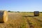 Harvested bales of straw in field in summer day on farmland country