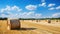 Harvested field with straw bales in summer, panoramic view.