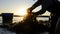 Harvested seaweed being rinsed in the ocean water by farmers, with the sun setting on the horizon