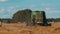 Harvester In An Agricultural Field Harvesting Crops With Beautiful Blue Sky In The Background