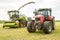 Harvester cutting field, loading Silage into a Tractor Trailer