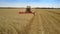 Harvester gathers heavy rye crop on field under blue sky