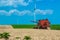 Harvester harvests ripe wheat on yellow rural field on a summer sunny day. Landscape of an endless agricultural field, blue sky