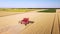 Harvester machine working in wheat field aerial view.