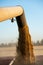 The harvester pours the ground grain into the truck on the field during harvest