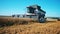 Harvester-thresher is reaping wheat off the field