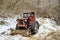 Harvester tractor snowy with wood trunks outside in forest