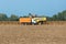 Harvesters harvest ripened sunflowers on a field.