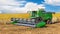 Harvesting combine among the wheat field and under a blue sky, harvesting in process,