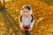 Harvesting, little beautiful girl with apples in autumn park