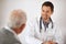 He has a great bedside manner. A young male doctor in a consultation with an elderly man.