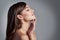 She has a picture perfect profile. Studio shot of a beautiful young woman posing against a gray background.