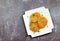 Hash browns on a white round plate on a light gray background.