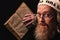 A Hasidic Jew reads Siddur. Religious orthodox Jew with a red beard and with pace in a white bale praying. Closeup