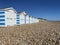 Hastings, East Sussex, UK -03.15.2022: Hastings seafront beach huts on summer day beautiful blue white striped huts on pebble beac