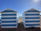 Hastings, East Sussex, UK -03.15.2022: Hastings seafront beach huts on summer day beautiful blue white striped huts on pebble beac