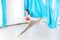 Hatha aero fly yoga concept. Beautiful young female trainer showing stretching exercises on blue hammock in white studio