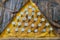 Hats of nails hammered into a wooden yellow pyramid. Freemasonry and its signs. Macro. Shallow depth of field