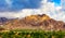 Hatta city welcoming sign written with large letters placed in Hajar mountains and UAE flag flying high in Hatta enclave of Dubai.