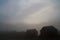 Haunting grey hazed image of cabins with a mountain looming in the background