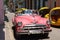 Havana, Cuba - August 25 2018: Classic cars and a bicycle are in a central street of Old Havana.