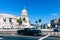 HAVANA, CUBA - DECEMBER 10, 2019: Brightly colored classic American cars serving as taxis pass on the main street in front of the