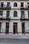 HAVANA, CUBA - FEB 22, 2016: Old woman sits in the entrance to a dilipitated building in Havana