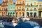 Havana, Cuba, tourists taking photos out of classic car in street with buildings in colonial style architecture
