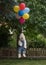 Havanese dog flying with colorful balloons