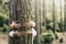 Have care about planet earth and earth`s day concept - couple of adult people hugging a tree in the wood with love and respect fo
