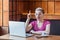 Have idea! Portrait of creative positive attractive young girl freelancer in pink t-shirt is sitting in cafe and working on laptop