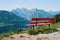 Have a rest in the swiss alps with a beautiful view on a wooden red bench.