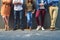 We have some serious style. a group unrecognizable people leaning against a wall while posing for a photo outside.