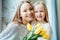 Having the best day with Mom.Mother and daughter together with bouquet of tulips