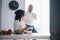 Having conversation. Senior man and his wife in white shirt have romantic dinner on the kitchen