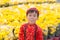 Having fun asian kid at marigold garden. Portrait of funny kid wearing Vietnamese traditional dress Ao Dai at Tet holiday