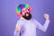 Having fun. Holiday fun and carnival concept. Man bearded wear colorful wig and funny glasses on violet background
