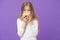 Having snacks. Child eat donut on violet background. Little girl with glazed ring doughnut on purple background. Kid