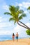 Hawaii beach couple walking on Kaanapali Maui Hawai travel. Two adults tourist on sunset stroll romantic vacation travel
