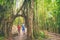 Hawaii hike hikers walking in lush rainforest trekking and hiking amongst banyan trees and bamboos, Oahu Travel. Couple