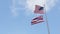 Hawaii State flag and American flag of USA waving on blue hawaiian sky
