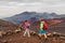 Hawaii volcano hikers people walking hiking on mountains in Haleakala volcanic background landscape. Two young tourists couple on