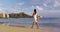 Hawaii Waikiki travel beach vacation - woman walking wearing hawaiian flower Lei