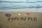 Hawaii written on the sand with snorkel an beach sleepers.