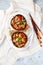 Hawaiian pinapple chicken in natural coconut shell plates on white background