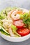 Hawaiian poke bowl with shrimps, rice and vegetables, healthy Buddha bowl with prawns, rice, avocado, cucumber, tomato and lettuce